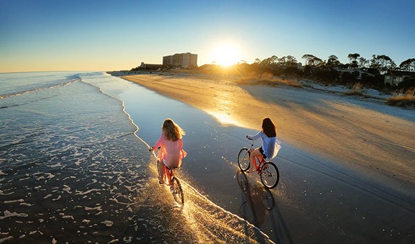 Girls riding bike on the beach