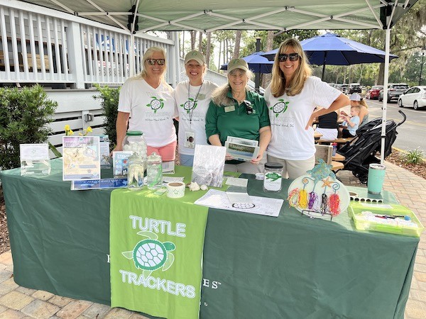 four volunteers at the Turtle Trackers booth set up outside of The General Store