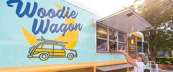woman getting food through the window from the Woodie Wagon food truck