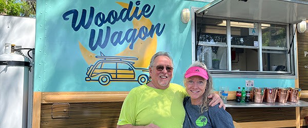 man and woman in front of the Woodie Wagon food truck