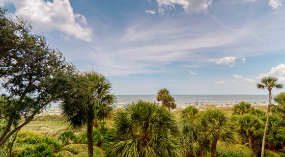 view of the ocean and trees from private balcony of Hilton Head vacation rental