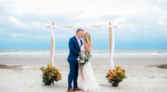 bride and groom kissing under the ceremony arbor on the Palmetto Dunes Beach