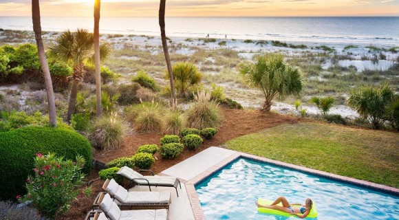 Girl floating in pool overlooking the ocean at a Palmetto Dunes Vacation Rental