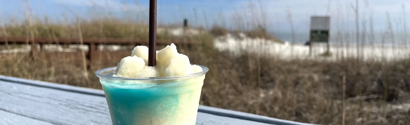 blue and white frozen drink on the deck of The Dunes House overlooking the beach dunes
